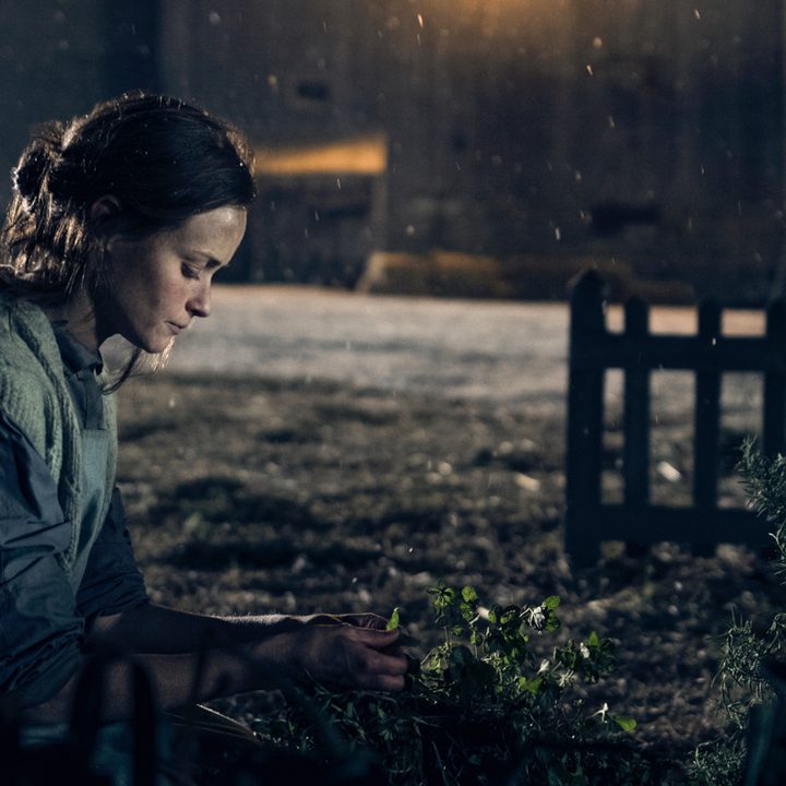 Ofglen (Alexis Bledel) tends to a plant