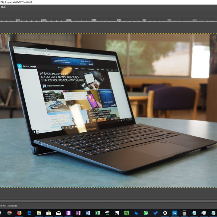 The GIMP photo editor interface in the middle of editing a photo of a laptop.