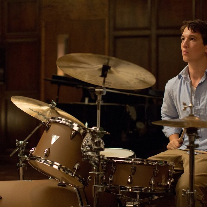 Miles Teller sits at a drum kit in Whiplash.