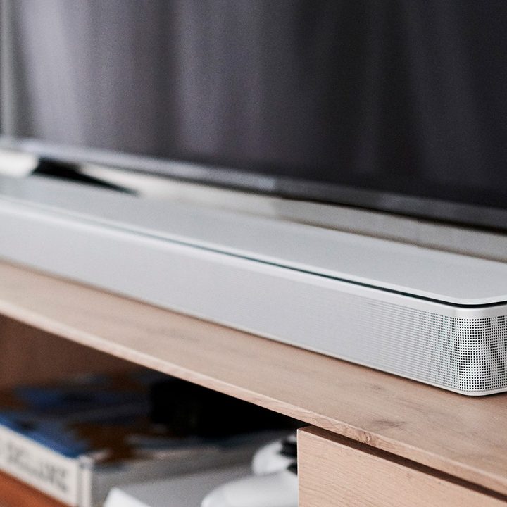 bose soundbar 700 white on top of entertainment center.
