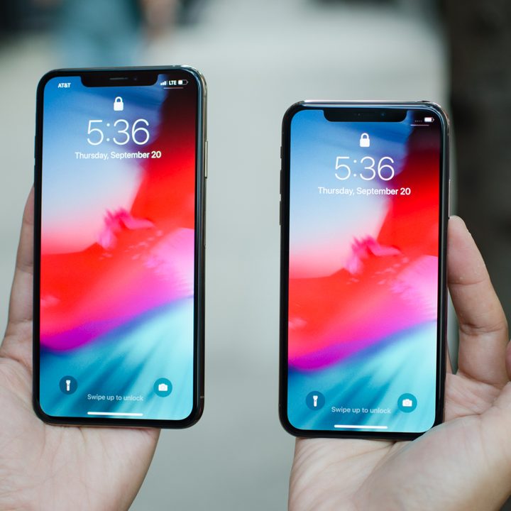 Two iPhones in hands.