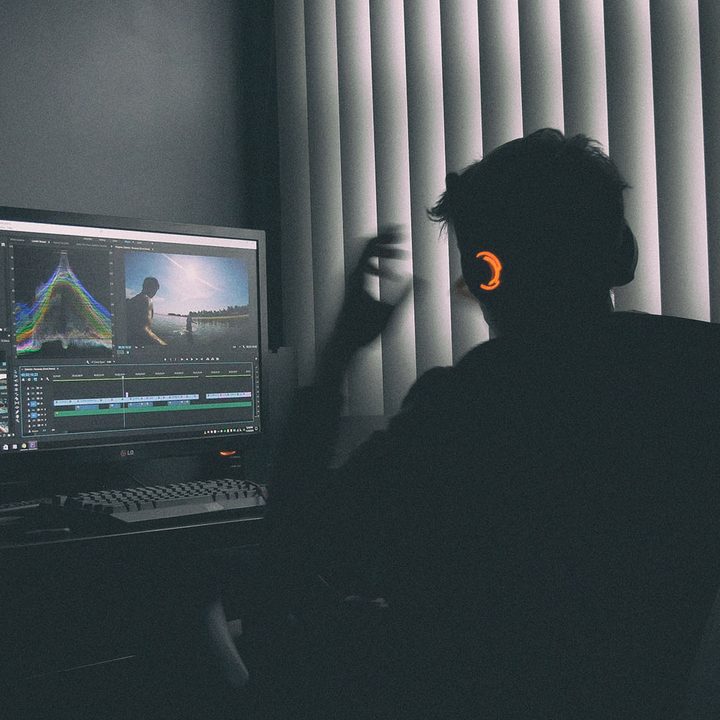 A person sitting in front of a PC using Adobe Premiere Pro.
