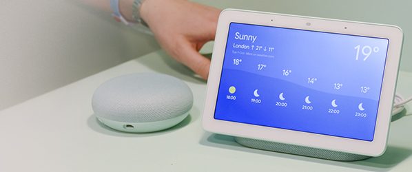 A Google home hub on a nightstand.