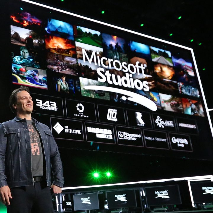 Phil Spencer standing in front of a Microsoft Studios logo.