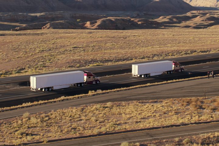 Semi trucks driving down a hilly road | Peloton Technologies