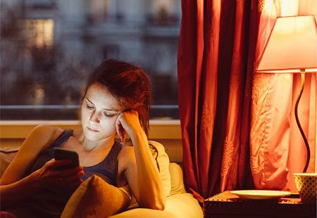 A person reading next to smart light bulb.