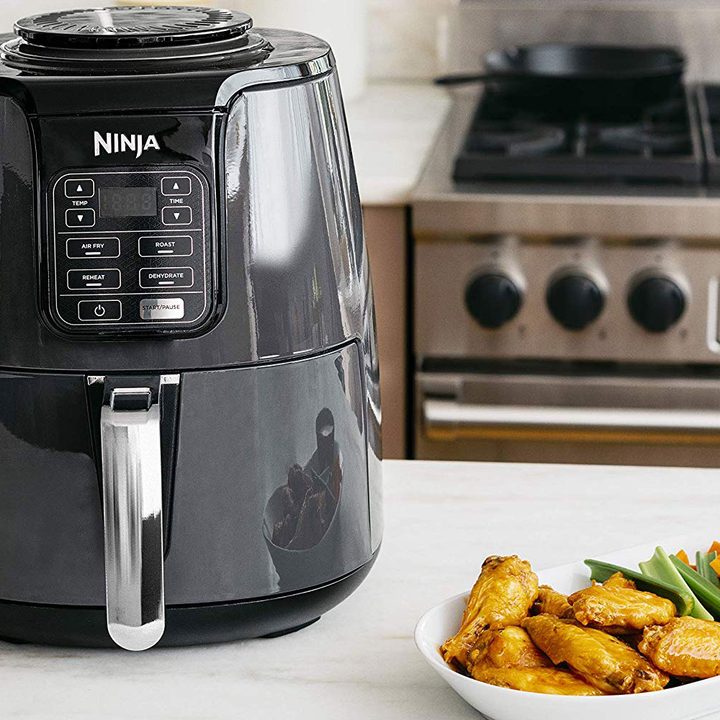 The Ninja 4-Quart Air Fryer with cooked food at the side.