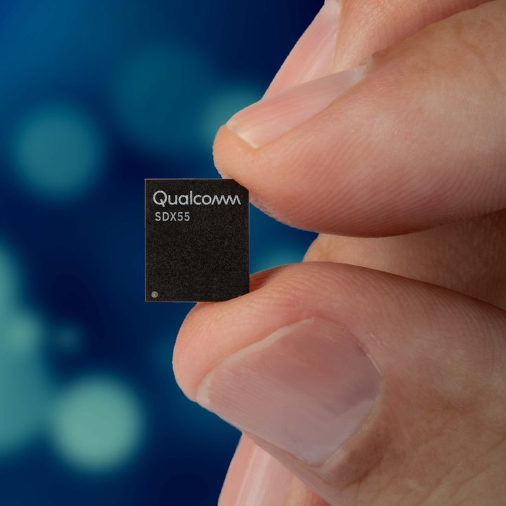 The Snapdragon X55 5G modem held using two fingers.