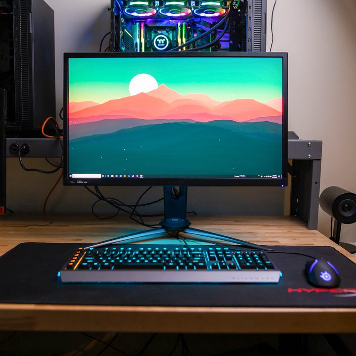 Acer Predator XB3 Gaming Monitor on a desk surrounded by other computer equipment.