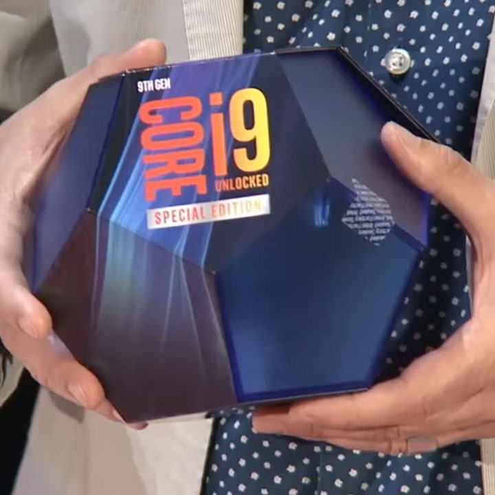 A pair of hands holding an Intel Core i9-9900KS CPU in the box.