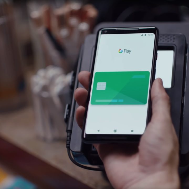 Person using Google Pay on an NFC terminal.