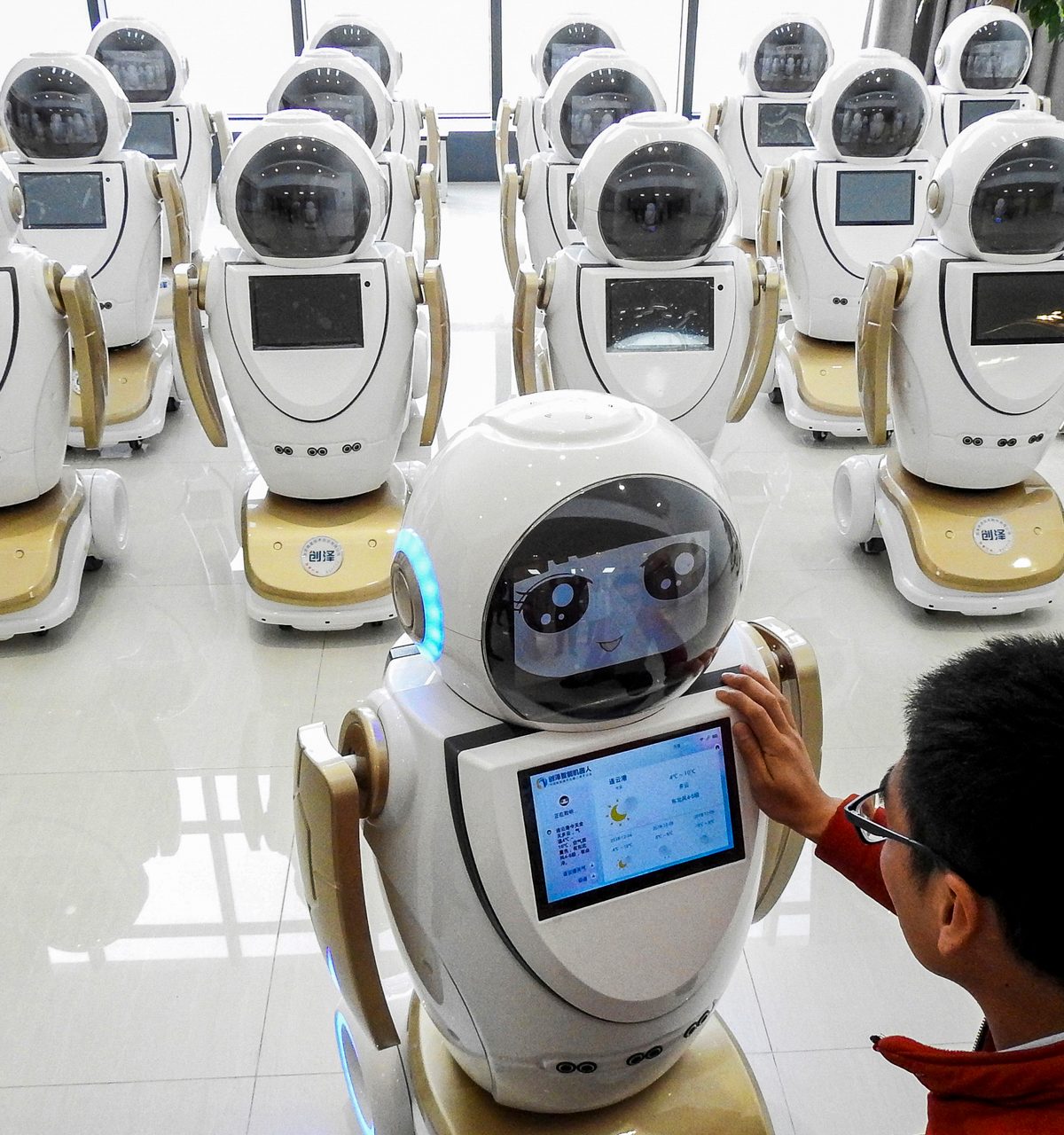 An employee programing robots for customer service
