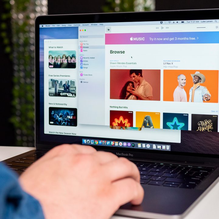 An image of someone using a MacBook Pro on a white table.