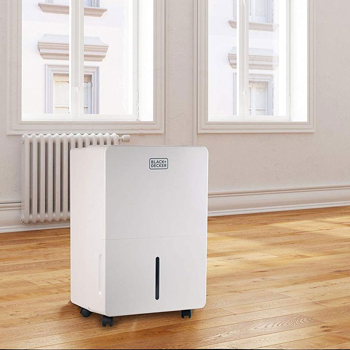 A Black + Decker dehumidifier in a living room.