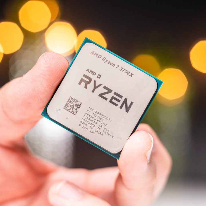 An AMD Ryzen 7 3700X held between a person's fingertips.