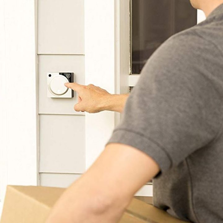 Delivery driver pressing doorbell button on video doorbell.