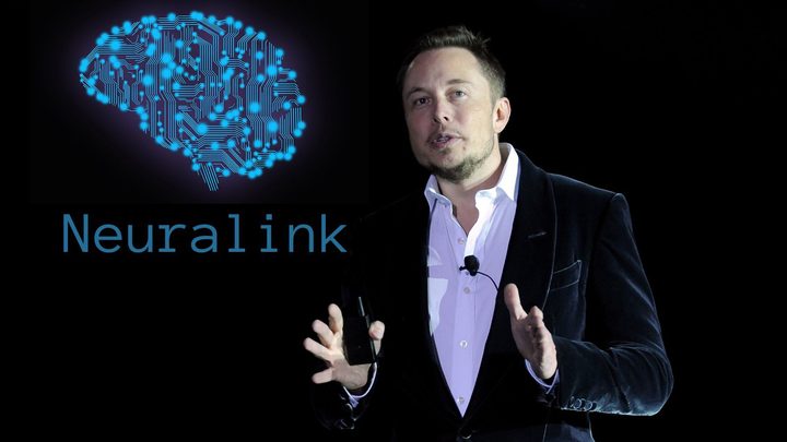 Elon Musk stands in front of the Neuralink logo.