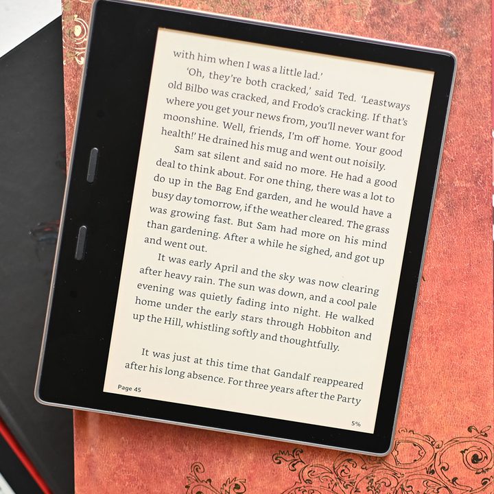 The Kindle Oasis on top of some books.