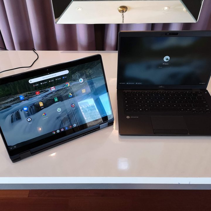 A pair of Dell Chromebooks sitting on a table.