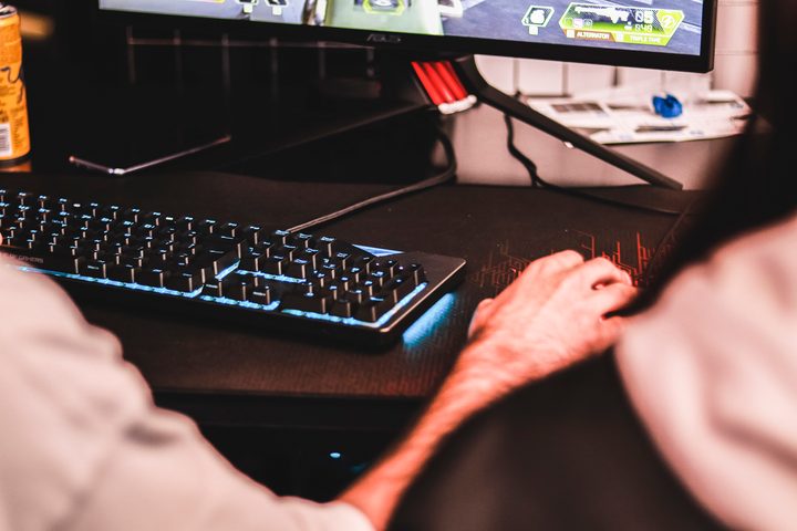 Gamer gaming using mouse and RGB keyboard