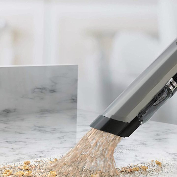 Using a vacuum wand to suck up a mess.
