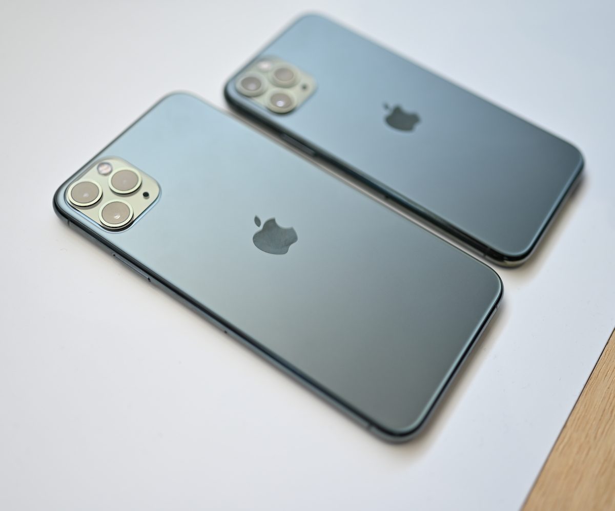 The backside of an iPhone 11 Pro Max and Pro, set on a table.