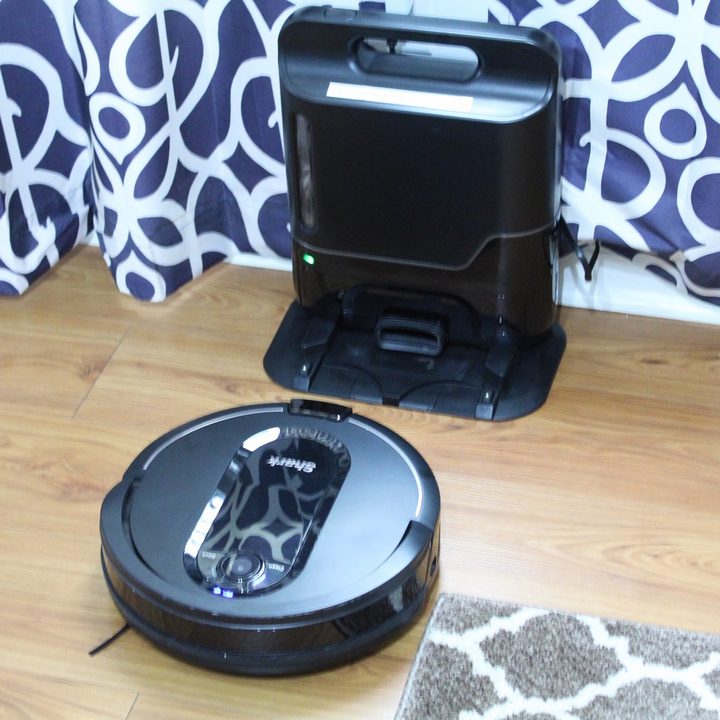 Shark robot vacuum docking with its auto-emptying base.