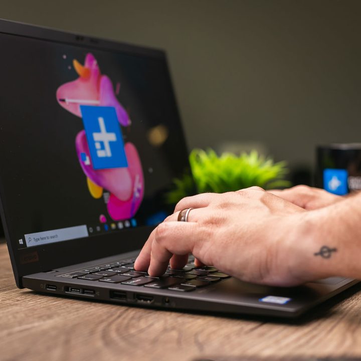 Person typing on Lenovo laptop.