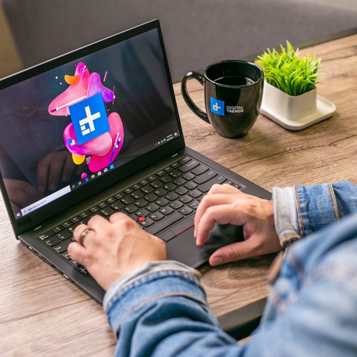 Man typing on Lenovo laptop.