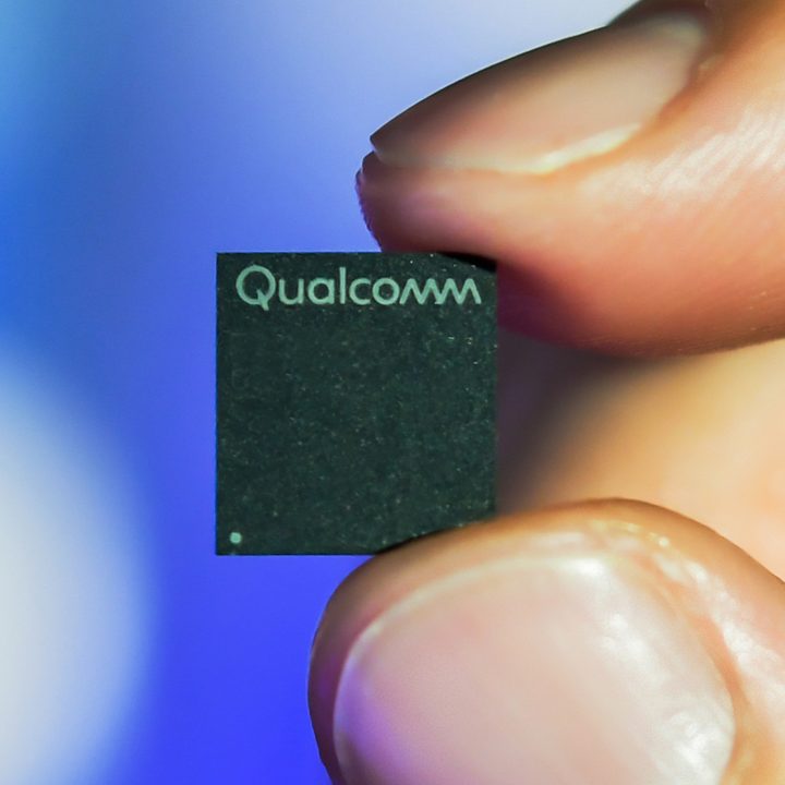 A Snapdragon 7C processor held between fingers.
