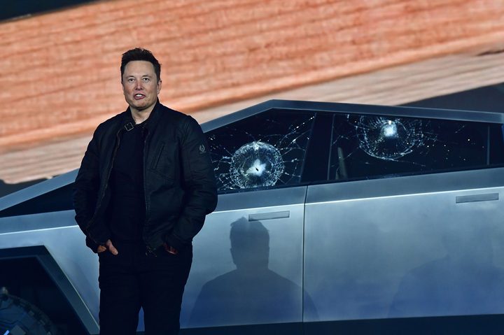 Tesla co-founder and CEO Elon Musk stands in front of the newly unveiled all-electric battery-powered Tesla's Cybertruck