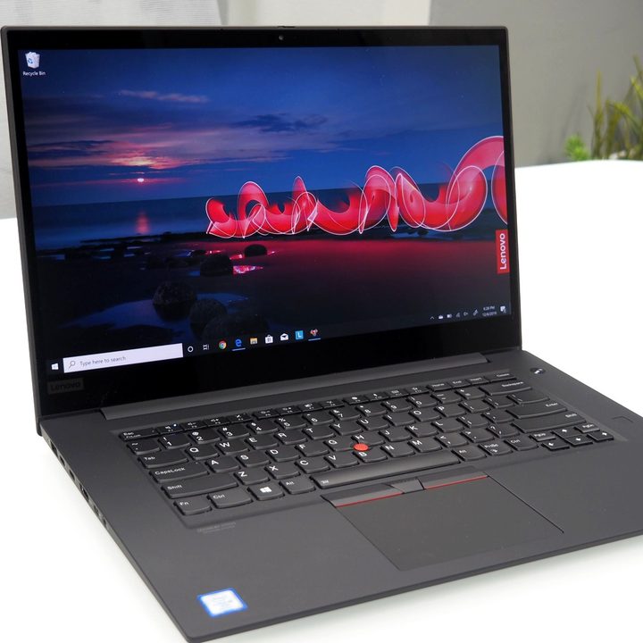 Lenovo laptop sitting on white table.