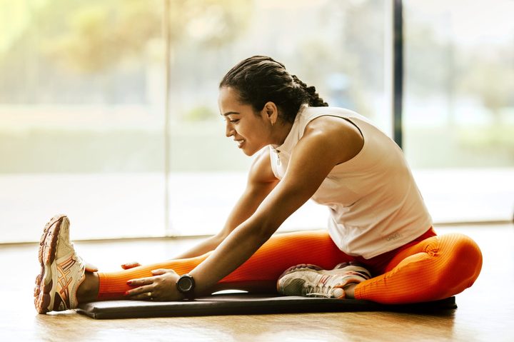 woman stretching in orange workout clothes