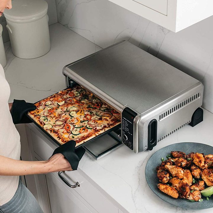 Removing pizza from Ninja Foodie Air Fryer oven.