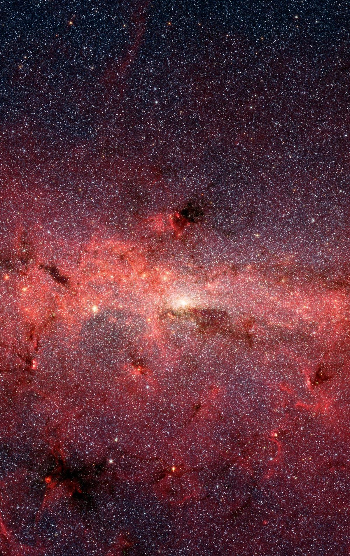 The center of our Milky Way galaxy is hidden from the prying eyes of optical telescopes by clouds of obscuring dust and gas. But in this stunning vista, the Spitzer Space Telescope's infrared cameras penetrate much of the dust, revealing the stars of the crowded galactic center region