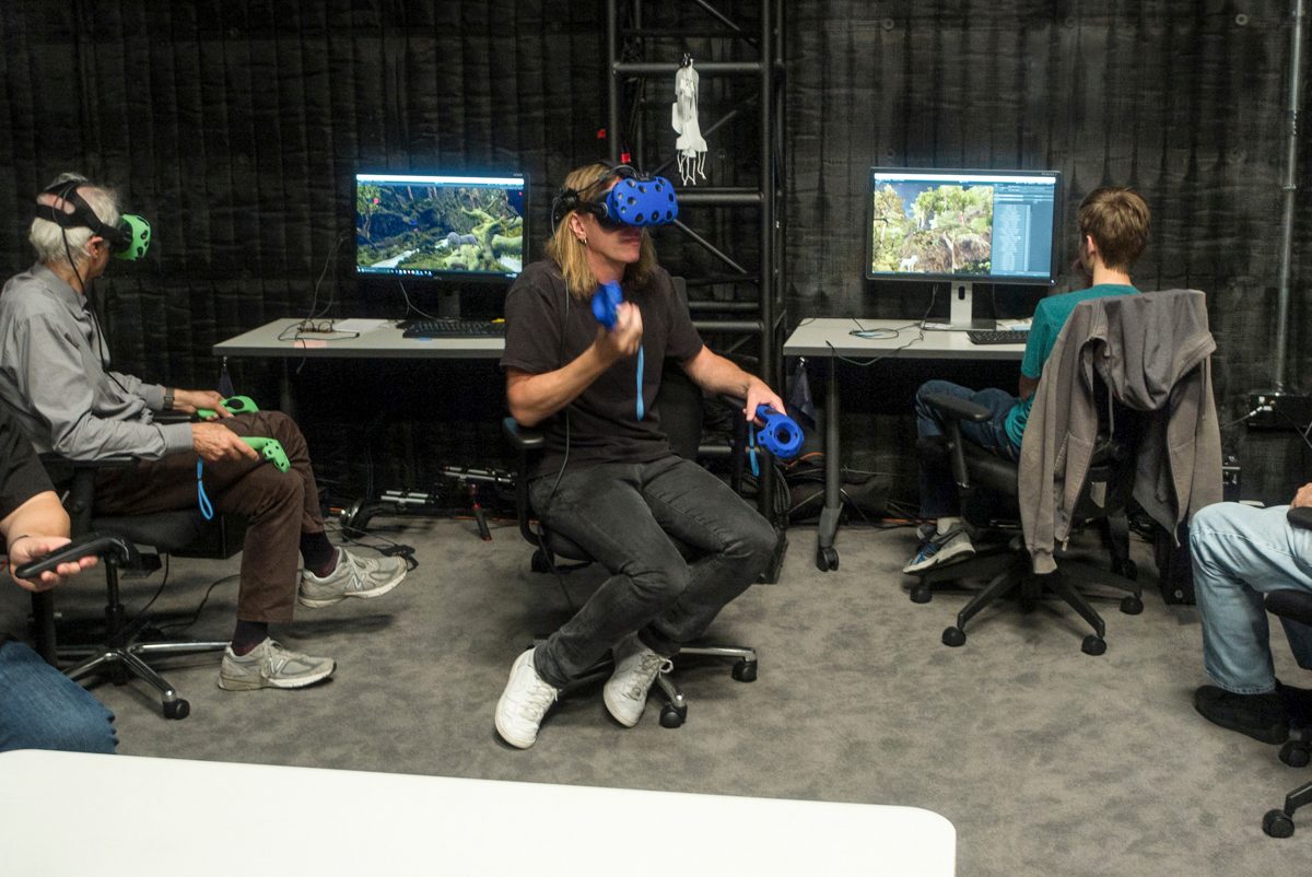 Director Jon Favreau (far left), cinematographer Caleb Deschanel, production designer James Chinlund (center), Legato (right) and animation supervisor Andy Jones (far right) look around a virtual scene prior to a VR shoot for The Lion King.
