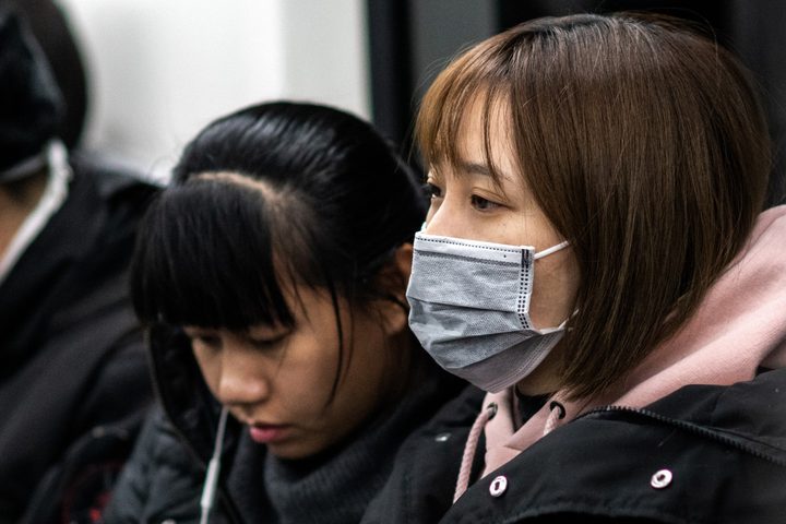 Woman wearing coronavirus mask on Beijing subway
