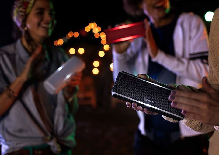 Multiple people using personal Bluetooth speakers.