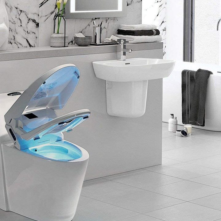 A bidet partially open and glowing blue in a bathroom.