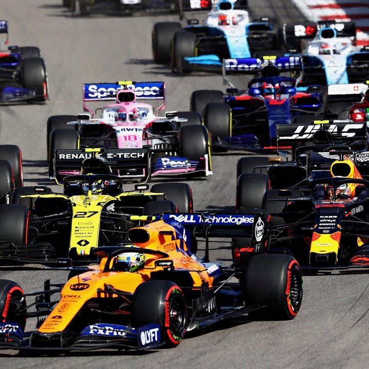 Formula One racing cars rounding a corner.