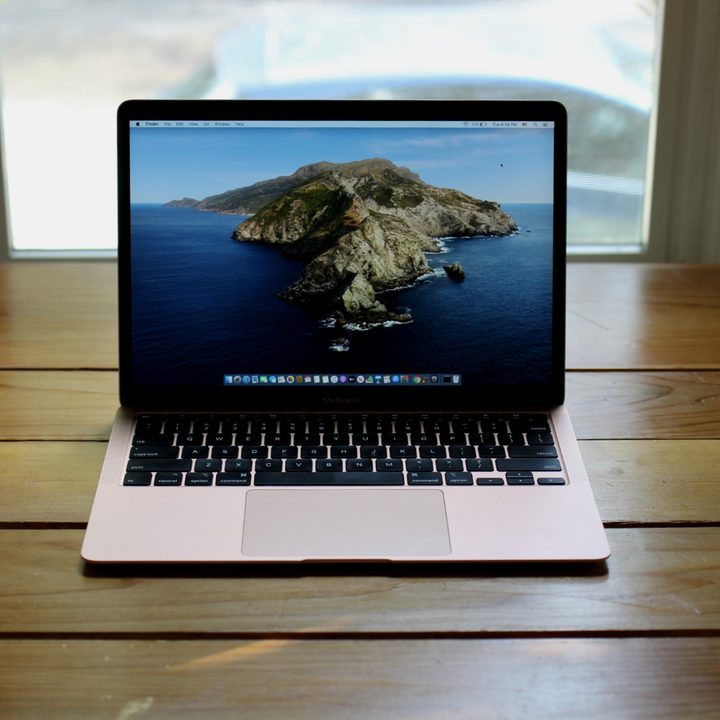 A MacBook Air 2020 open on a wooden table.