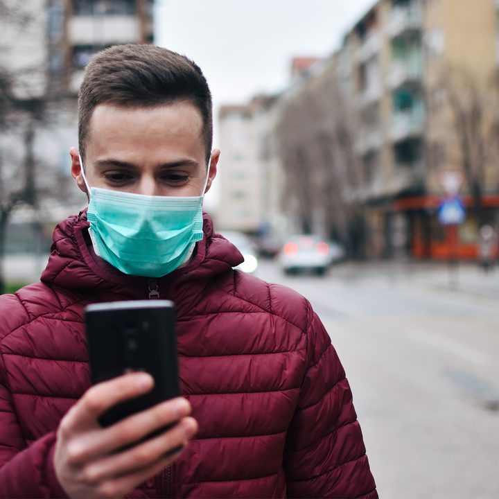 man checking phone with mask on