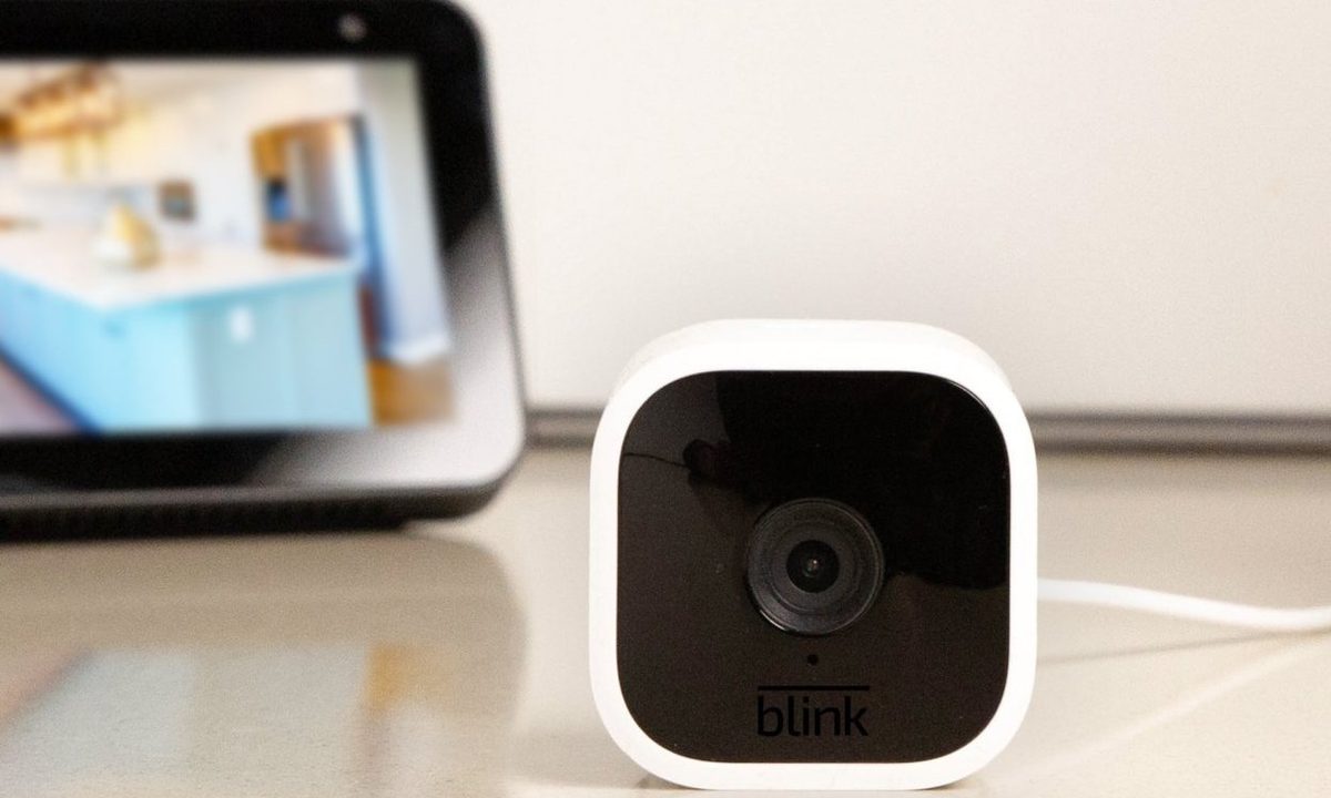 Blink Mini sitting on a table in front of Echo show
