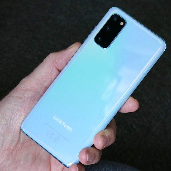 The Galaxy S20 5G in hand in Cloud Blue, showing the back of the phone and camera module.