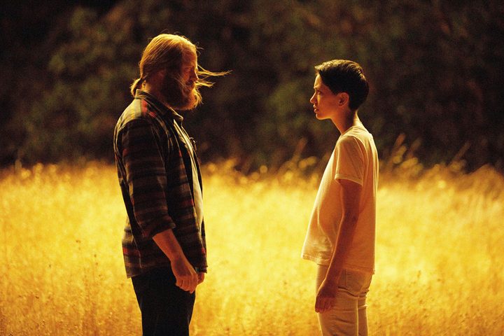 A man and woman stare at each other in a field.