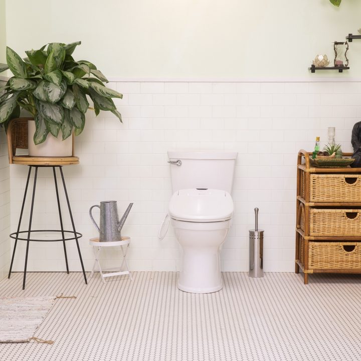 A bidet toilet attachment in a home bathroom.
