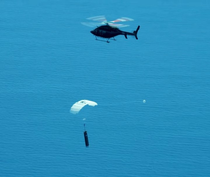 A helicopter plucks a dummy booster from the sky during a test run by Rocket Lab in 2020.