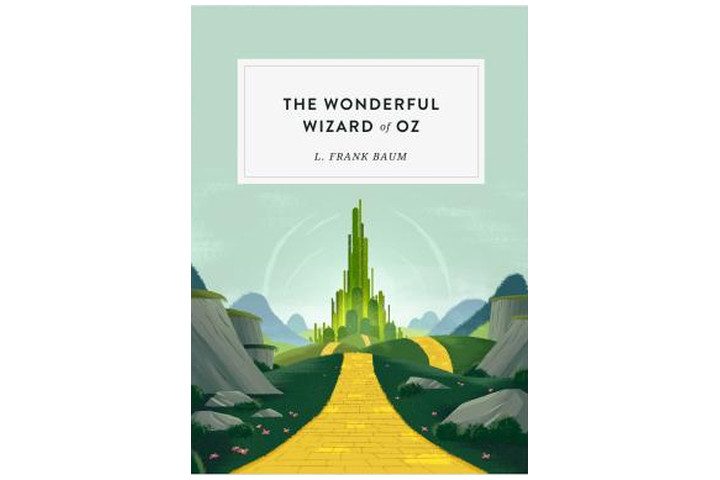 Photo shows the book cover of The Wonderful Wizard of Oz, with the yellow brick road leading towards the emerald city. The book title is written in large black letters and the author's name is in smaller letters beneath it