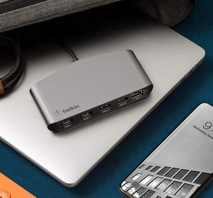 Belkin Thunderbolt 3 Dock Mini sitting on a laptop beside a travel case.