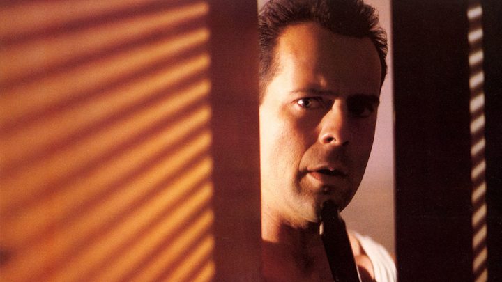 John McClane peeking from behind a wall in Die Hard